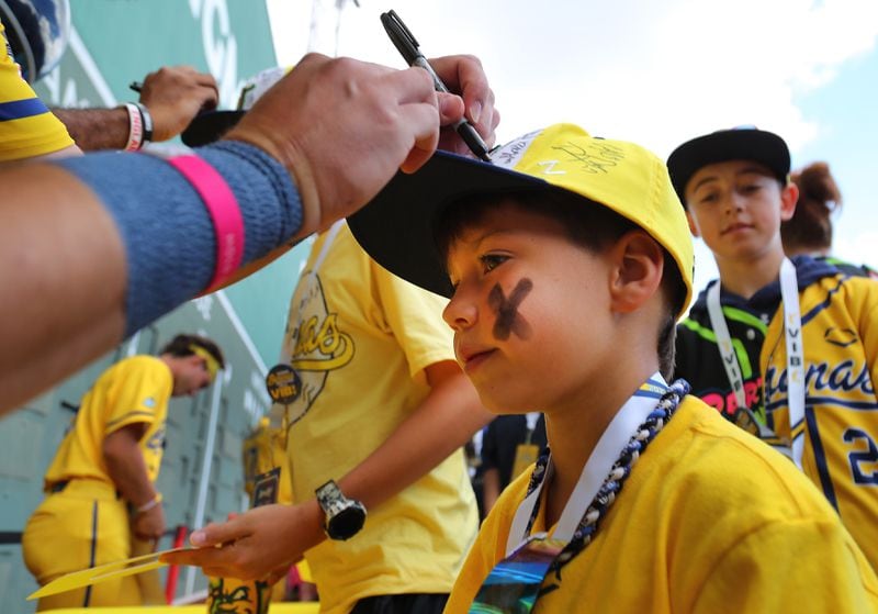 Coen Hosford, 8, gets his hat autographed in the outfield before The Savannah Bananas play the Party Animals at Fenway Park in Boston on Saturday, June 8, 2024. (John Tlumacki/The Boston Globe)