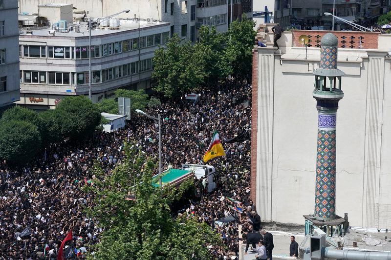 Iranians follow a truck carrying coffins of the late President Ebrahim Raisi and his companions who were killed in a helicopter crash on Sunday in a mountainous region of the country's northwest, during a funeral ceremony for them in Tehran, Iran, Wednesday, May 22, 2024. Iran's supreme leader presided over the funeral Wednesday for the country's late president, foreign minister and others killed in the helicopter crash, as tens of thousands later followed a procession of their caskets through the capital, Tehran. (AP Photo/Vahid Salemi)