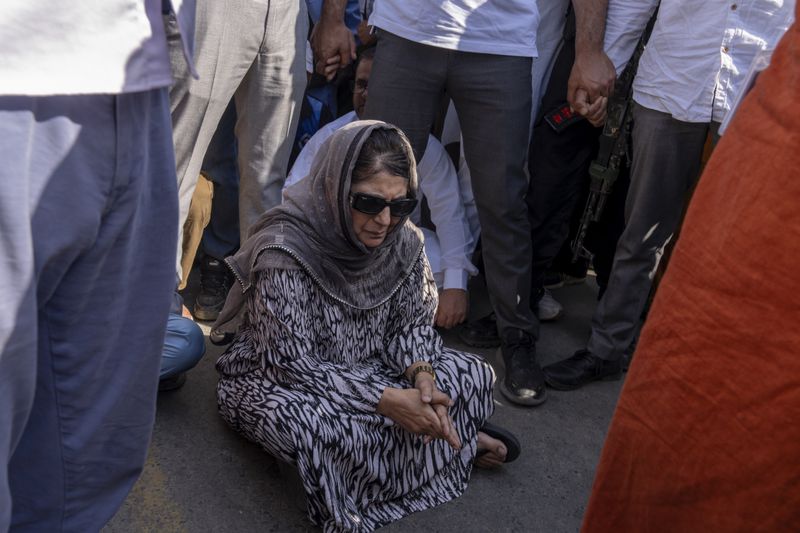 Jammu and Kashmir Peoples Democratic Party(PDP) President Mehbooba Mufti, center, blocks a road with her supporters as she protests against the alleged detention of her party workers ahead of the sixth round of polling in India's national election in Bijehara, south of Srinagar, Indian controlled Kashmir, Saturday, May 25, 2024. (AP Photo/Dar Yasin)