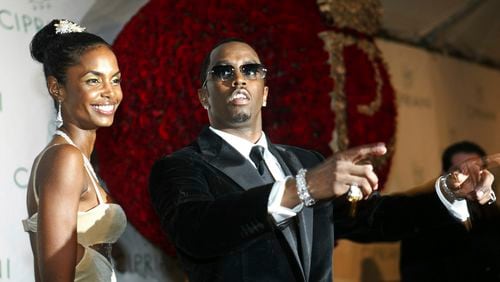 FILE - Sean "P. Diddy" Combs directs photographers as they sing "Happy Birthday," to him as his date Kim Porter, left, listens, after Combs arrived for his 35th birthday celebration at Cipriani on Wall Street in New York, Nov. 4, 2004. (AP Photo/Kathy Willens, File)