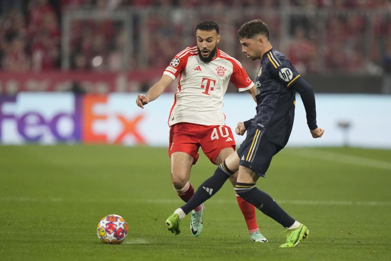 FILE -Bayern's Noussair Mazraoui, left, challenges Real Madrid's Federico Valverde during the Champions League semifinal first leg soccer match between Bayern Munich and Real Madrid at the Allianz Arena in Munich, Germany, Tuesday, April 30, 2024. (AP Photo/Matthias Schrader, File)