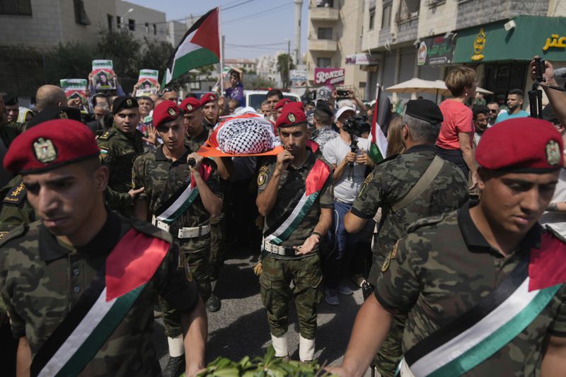 A Palestinian honor guard carries the body of Aysenur Ezgi Eygi, 26, who was fatally shot by Israeli soldiers while participating in an anti-settlement protest in the West Bank, during her funeral procession in the West Bank city of Nablus, Monday, Sept. 9, 2024. (AP Photo/Nasser Nasser)