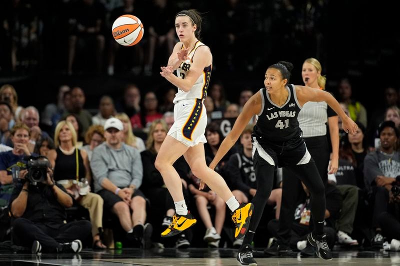 Indiana Fever guard Caitlin Clark (22) passes against Las Vegas Aces center Kiah Stokes (41) during the first half of a WNBA basketball game Saturday, May 25, 2024, in Las Vegas. (AP Photo/John Locher)