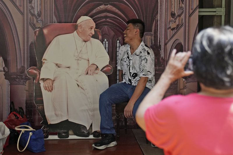 A man has his photo taken with a cutout of Pope Francis displayed at Jakarta Cathedral ahead of his visit to Indonesia from Sept. 3-6, in Jakarta, Indonesia, Sunday, Sept. 1, 2024. (AP Photo/Dita Alangkara)