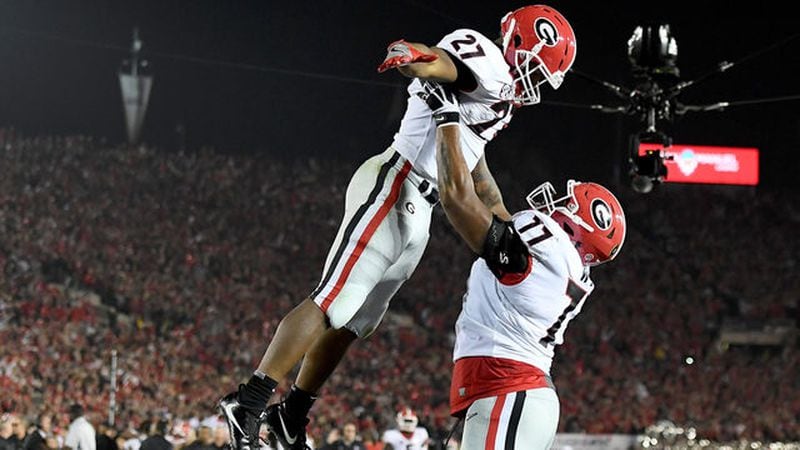 Nick Chubb #27 of the Georgia Bulldogs and Isaiah Wynn #77 celebrate after Chubb scores a touchdown in the 2018 College Football Playoff Semifinal Game against the Oklahoma Sooners at the Rose Bowl Game. (Photo by Harry How/Getty Images)