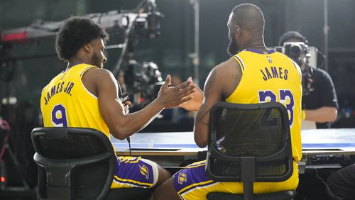 Los Angeles Lakers' LeBron James, right, and his son, Bronny James Jr, shake hands after an interview during the NBA basketball team's media day in El Segundo, Calif., Monday, Sept. 30, 2024. (AP Photo/Jae C. Hong)