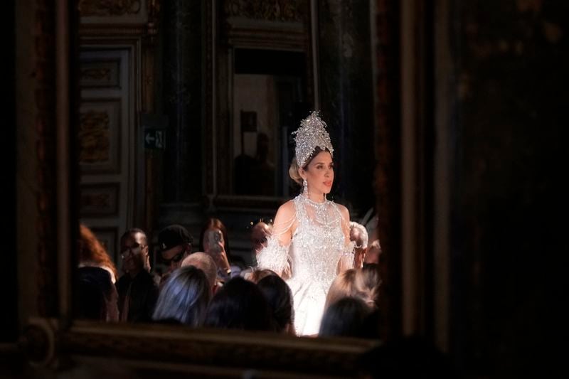 Reflected in a mirror, Emma Coronel, wife of Joaquin "El Chapo" Guzman, wears a creation as part of the April Black Diamond Spring Summer 2025 collection, in Milan, Italy, Sunday, Sept. 22, 2024. (AP Photo/Antonio Calanni)