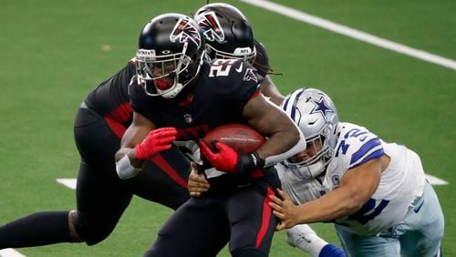 Falcons running back Brian Hill (23) runs the ball as Dallas Cowboys defensive tackle Trysten Hill (72) attempts to make a stop  Sunday, Sept. 20, 2020, in Arlington, Texas. (Michael Ainsworth/AP)