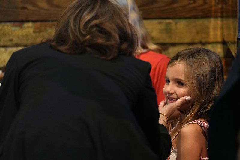 Democratic presidential nominee Vice President Kamala Harris talks to a young child as she visits SandFly Bar-B-Q in Savannah, Ga., Wednesday, Aug. 28, 2024. (AP Photo/Jacquelyn Martin)