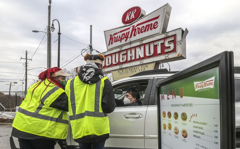 Alondria Folks and Marceria Edge take the order of customer Leigh Strawn at the pop-up Krispy Kreme.