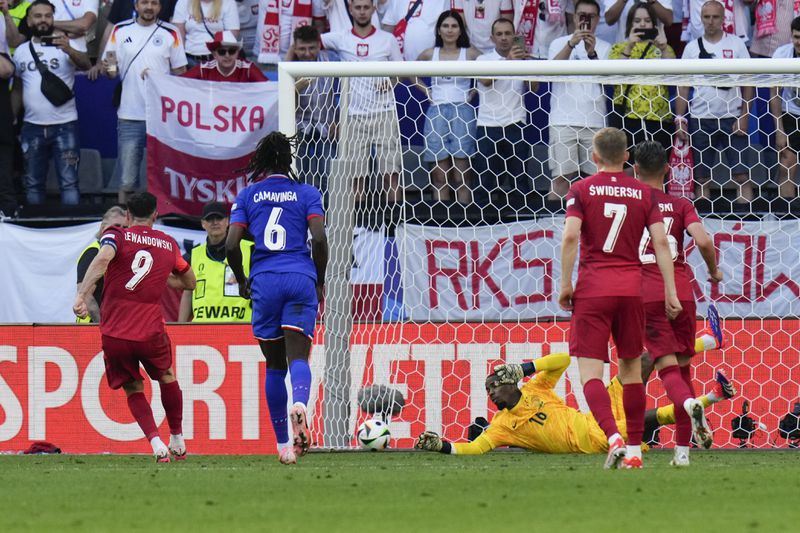 Poland's Robert Lewandowski, left, scores on a penalty kick during a Group D match between France and Poland at the Euro 2024 soccer tournament in Dortmund, Germany, Tuesday, June 25, 2024. (AP Photo/Hassan Ammar)