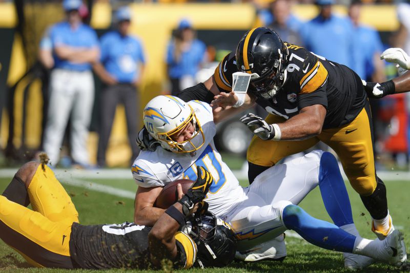 Los Angeles Chargers quarterback Justin Herbert (10) is sacked by Pittsburgh Steelers linebacker Elandon Roberts, bottom left, during the second half of an NFL football game, Sunday, Sept. 22, 2024, in Pittsburgh. (AP Photo/Gene J. Puskar)