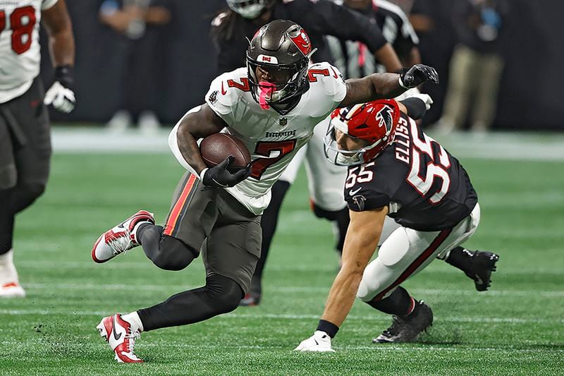 Tampa Bay Buccaneers running back Bucky Irving (7) runs past Atlanta Falcons linebacker Kaden Elliss (55) during the second half of an NFL football game Thursday, Oct. 3, 2024, in Atlanta. (AP Photo/Butch Dill)