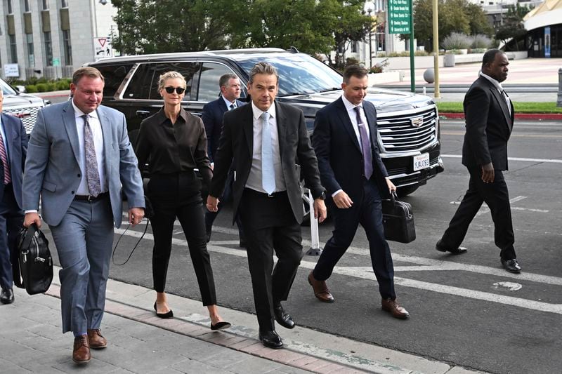 Lachlan Murdoch, center, and his wife Sarah arrive at the Second Judicial District Court in Reni, Nev. on Monday Sept. 16, 2024. (AP Photo/Andy Barron)