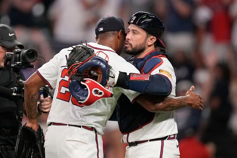 Atlanta Braves pitcher Raisel Iglesias (26) celebrates with Travis d'Arnaud (16) after a win against the San Francisco Giants, Wednesday, July 3, 2024, in Atlanta. (AP Photo/Brynn Anderson)