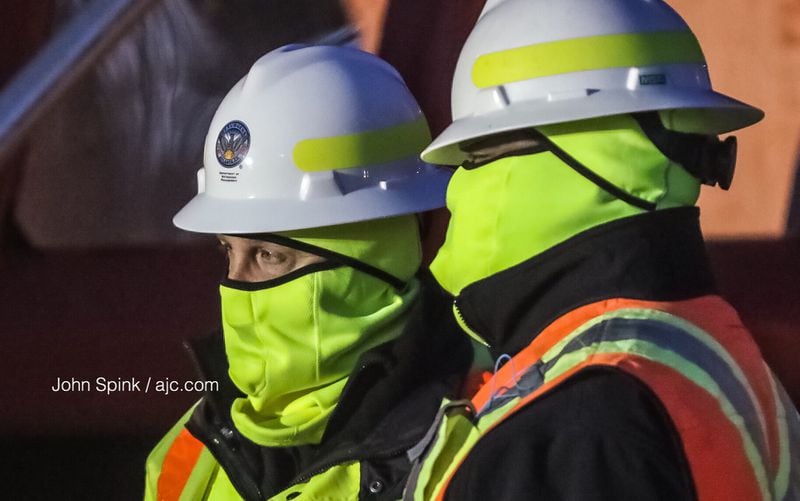 Carl Long (left) and Anthony Jones with the Atlanta Department of Watershed Management work in freezing temperatures Tuesday to repair a 30-inch water main that broke Monday at Fairburn Road near Cascade Road. JOHN SPINK / JSPINK@AJC.COM