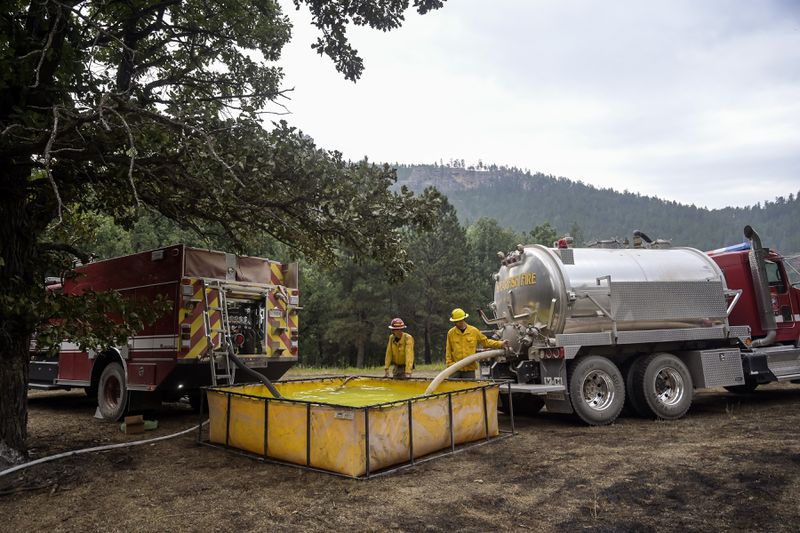 A water shuttle operation runs as tankers fill a drop tank as hotshots work the First Thunder Fire on Wednesday, Sept. 4, 2024, west of Rapid City in the Black Hills, S.D. (Matt Gade/Rapid City Journal via AP)