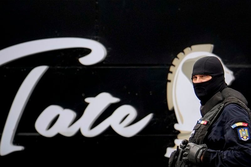 A masked gendarme patrols the courtyard of the residence of internet influencer Andrew Tate during an early morning police search raid, on the outskirts of Bucharest, Romania, Wednesday, Aug. 21, 2024. (AP Photo/ Vadim Ghirda)