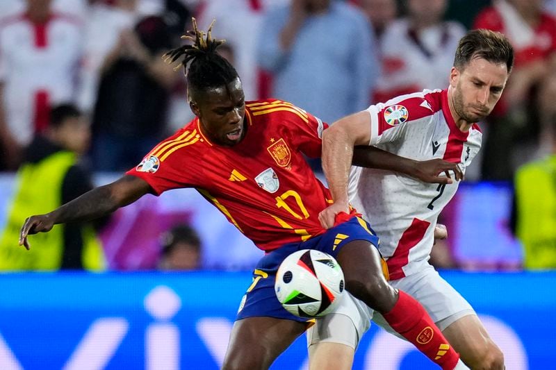 Georgia's Otar Kakabadze, right, challenges Spain's Nico Williams during a round of sixteen match between Spain and Georgia at the Euro 2024 soccer tournament in Cologne, Germany, Sunday, June 30, 2024. (AP Photo/Manu Fernandez)