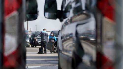 FILE - Amazon drivers wait next to their delivery vans after logistics systems went offline at the Amazon Delivery Station in Rosemead, Calif., Dec. 7, 2021. (AP Photo/Damian Dovarganes, File)