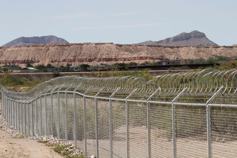 A privately owned fence extends toward the U.S. border, with Mexico in the distance, where restaurant co-owner Robert Ardovino has attempted to route migrants around the center of his property, shown Thursday, Aug. 22, 2024 in Sunland, Park, N.M. Ardovino has a close-up view of border enforcement efforts and bristles at politicians talking from afar about an "open border." The politics of immigration look different from communities on the Southwest border that are voting in hotly contested congressional races. (AP Photos/Morgan Lee)