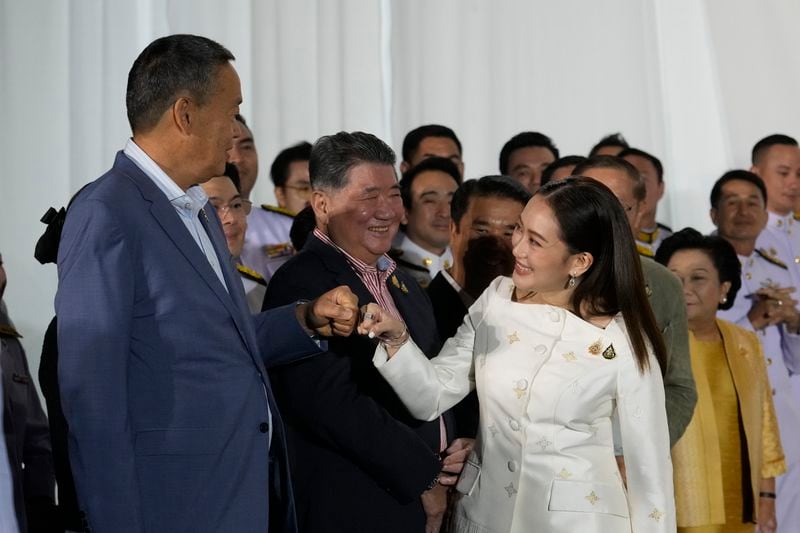 Thailand's former Prime Minister Srettha Thavisin, left, exchanges a fist bump with new Prime Minister Paetongtarn Shinawatra after Paetongtarn received a royal letter of endorsement for the post at the Pheu Thai party headquarters in Bangkok, Thailand Sunday, Aug. 18, 2024. (AP Photo/Sakchai Lalit)