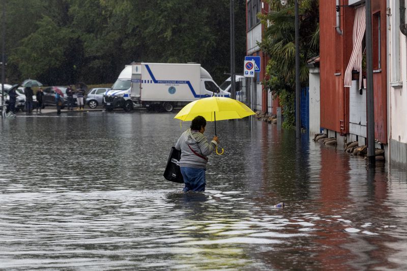 A woman wades through floodwater due to heavy rain in a street in Milan, Italy, Thursday Sept. 5, 2024. (Stefano Porta/LaPresse via AP)