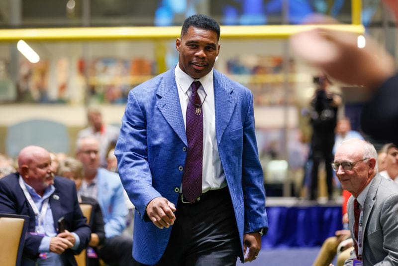 U.S. Senate hopeful Herschel Walker walks up to be inducted to the inaugural Georgia High School Football Hall of Fame at the College Football Hall of Fame in Atlanta on Oct. 22, 2022. (Arvin Temkar/AJC)