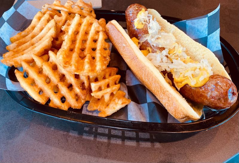 The beer bratwurst and waffle fries are menu favorites at Round Trip Brewing in Marietta. (Bob Townsend for The Atlanta Journal-Constitution)