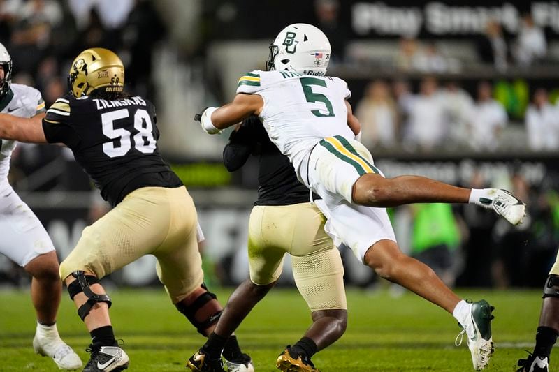 Baylor linebacker Garmon Randolph, front, sacks Colorado quarterback Shedeur Sanders in the second half of an NCAA college football game Saturday, Sept. 21, 2024, in Boulder, Colo. (AP Photo/David Zalubowski)