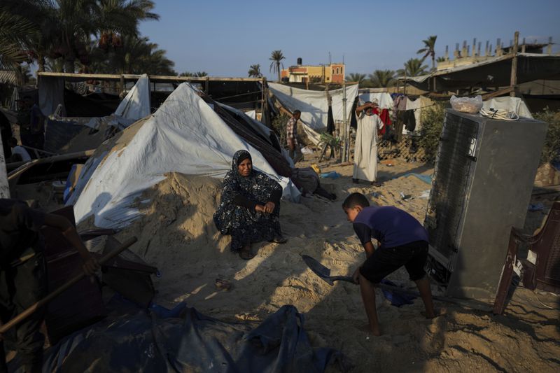 Palestinians look at the destruction after an Israeli airstrike on a crowded tent camp housing Palestinians displaced by the war in Muwasi, Gaza Strip, Tuesday, Sept. 10, 2024. An Israeli strike killed at least 40 people and wounded 60 others early Tuesday, Palestinian officials said. Israel said it targeted "significant" Hamas militants, allegations denied by the militant group. (AP Photo/Abdel Kareem Hana)