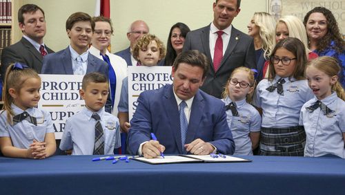 FILE - Florida Gov. Ron DeSantis signs the Parental Rights in Education bill at Classical Preparatory school on March 28, 2022, in Shady Hills, Fla. (Douglas R. Clifford/Tampa Bay Times via AP, File)