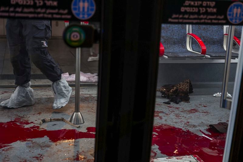 EDS NOTE: GRAPHIC CONTENT - Israeli forensic technicians work in a light rail car following a shooting attack in Jaffa, a mixed Arab-Jewish area of Tel Aviv, Israel, Tuesday, Oct. 1, 2024. (AP Photo/Itai Ron)