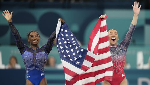 Simone Biles, left, celebrates with teammate Suni Lee, of the United States, after winning the gold and bronze medals respectively in the women's artistic gymnastics all-around finals in Bercy Arena at the 2024 Summer Olympics, Thursday, Aug. 1, 2024, in Paris, France. (AP Photo/Natacha Pisarenko)
