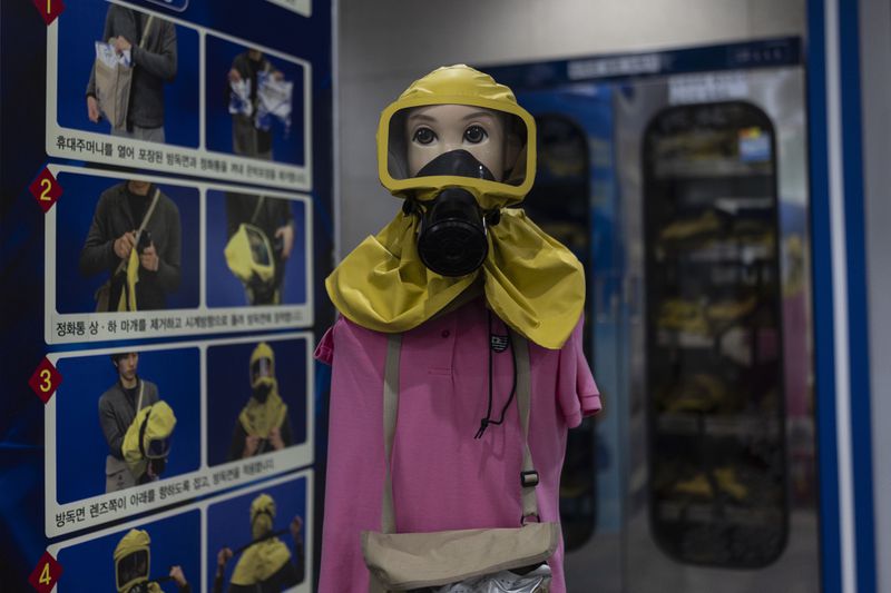 A mannequin wearing a gas mask stands next to a board explaining how to put it on at the War Memorial of Korea in Seoul, Wednesday, May 29, 2024. (AP Photo/Jae C. Hong)