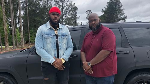 Georgia offensive tackle Andrew Thomas (L) poses with Kevin Johnson, his position coach at Pace Academy, in the driveway of Johnson's Fayetteville home Thursday. There, pupil and coach were taking in the first round of the NFL draft. (Special photo)