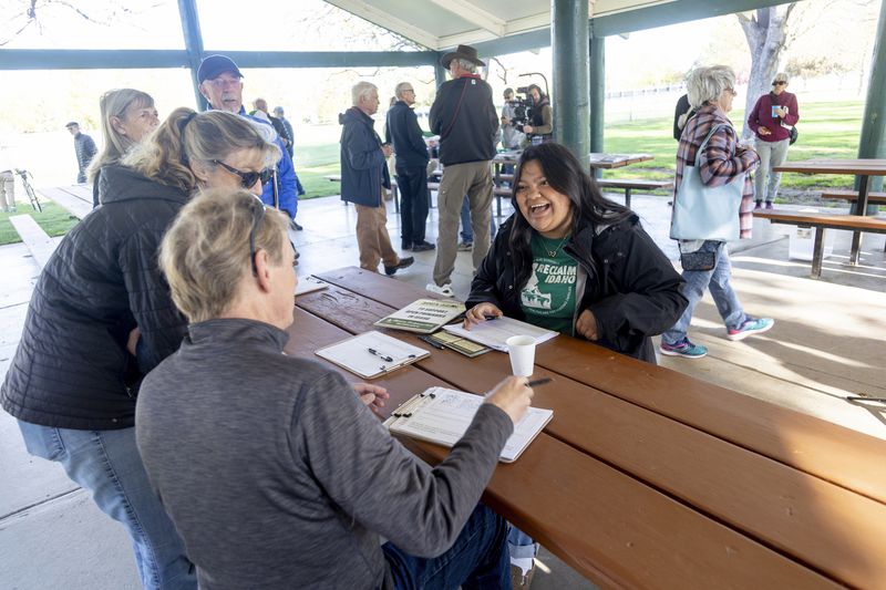Olivia Luna, right, statewide field fellow for Idahoans for Open Primaries talks with volunteers supporting the Idaho open primaries ballot initiative during a gathering at Ivywild Park in Boise, Idaho on April 27, 2024. Idahoans for Open Primaries has been collecting signatures to get open primaries and ranked choice voting on the November ballot, which they say will open Idaho's closed primary system that excludes 270,000 people who consider themselves Independents. (AP Photo/Kyle Green)