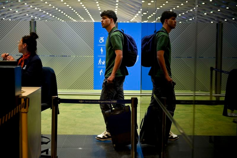 French rugby player Hugo Auradou holds a suitcase at the airport in Buenos Aires, Argentina, Tuesday, Sept. 3, 2024. Argentine prosecutors decided to let Auradou and teammate Oscar Jegou leave the country despite the players remaining under investigation for alleged rape. (AP Photo/Gustavo Garello)