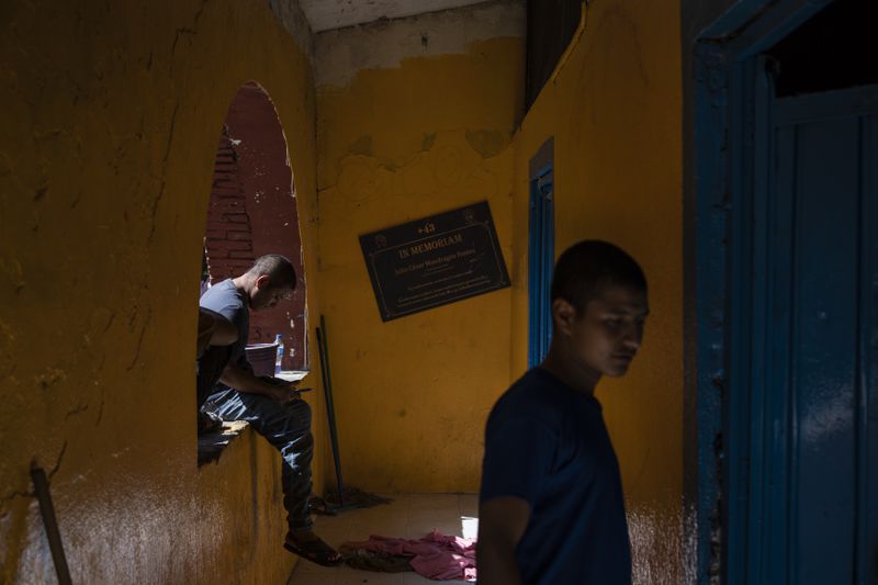 First-year student Jesus Castro Rafaela walks inside the Raúl Isidro Burgos Rural Normal School where a sign memorializes Julio Cesar Mondragon Fontes, a student who died on the night that 43 fellow students went missing, in Ayotzinapa, Guerrero state, Mexico, Monday, Aug. 26, 2024. (AP Photo/Felix Marquez)