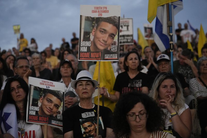 Relatives and friends of hostages held in the Gaza Strip by the Hamas militant group gather on an amphitheater during a protest calling for their release after taking part in a convoy of vehicles, outside the kibbutz Be'eri, southern Israel, Wednesday, Aug. 28, 2024. (AP Photo/Tsafrir Abayov)