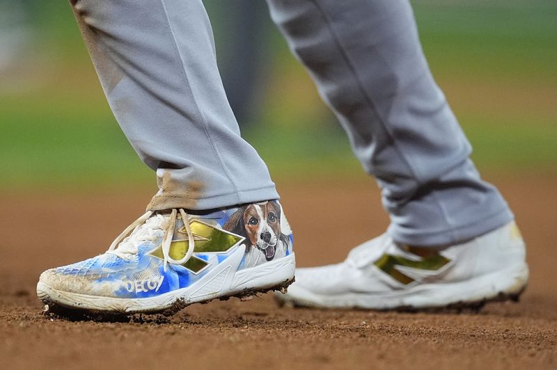 Los Angeles Dodgers' Shohei Ohtani wears a pair of spikes adorned with a photograph of his dog, Decoy, in the fifth inning of a baseball game against the Colorado Rockies, Saturday, Sept. 28, 2024, in Denver. (AP Photo/David Zalubowski)