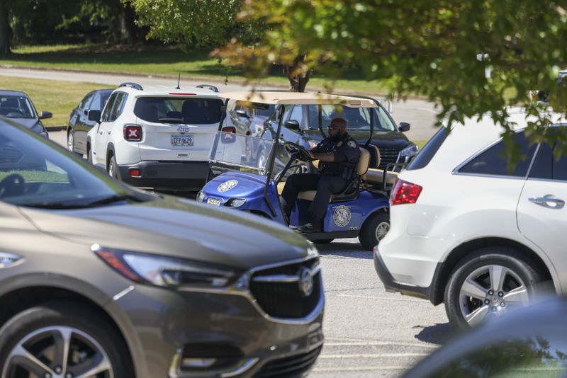 School Resource Officer Tierre Roby drives a golf cart to patrol the exterior of Jackson Elementary School in early May. (Jason Getz / Jason.Getz@ajc.com)