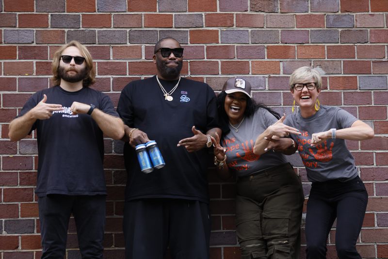 Peter Kiley (from left), brewmaster at Monday Night Brewery, rapper Killer Mike and PAWKids founder LaTonya Gates and board director Elisabeth Irwin pose Wednesday, Sept. 20, 2023, for a photograph to celebrate the partnership that will produce a beer to benefit the nonprofit organization. The hand gestures are the symbol for the rap group Run the Jewels. (Photo: Miguel Martinez / miguel.martinezjimenez@ajc.com)