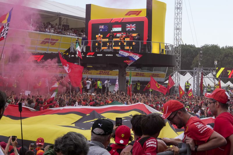 Ferrari driver Charles Leclerc of Monaco, centre, celebrates on the podium with second placed McLaren driver Oscar Piastri of Australia, left, and third McLaren driver Lando Norris of Britain after the Formula One Italian Grand Prix race at the Monza racetrack, in Monza, Italy, Sunday, Sept. 1, 2024. (AP Photo/Luca Bruno)