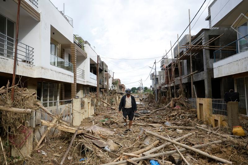 A man walks on a street strewn with debris in Kathmandu, Nepal, Monday, Sept. 30, 2024 in the aftermath of a flood caused by heavy rains. (AP Photo/Gopen Rai)