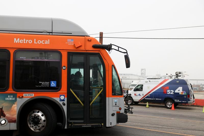 A bus passes by a news van in front of a Los Angeles MTA bus depot near the site where overnight a bus was hijacked by an armed subject with passengers on board Wednesday, Sept. 25, 2024, in Los Angeles. (AP Photo/Ryan Sun)