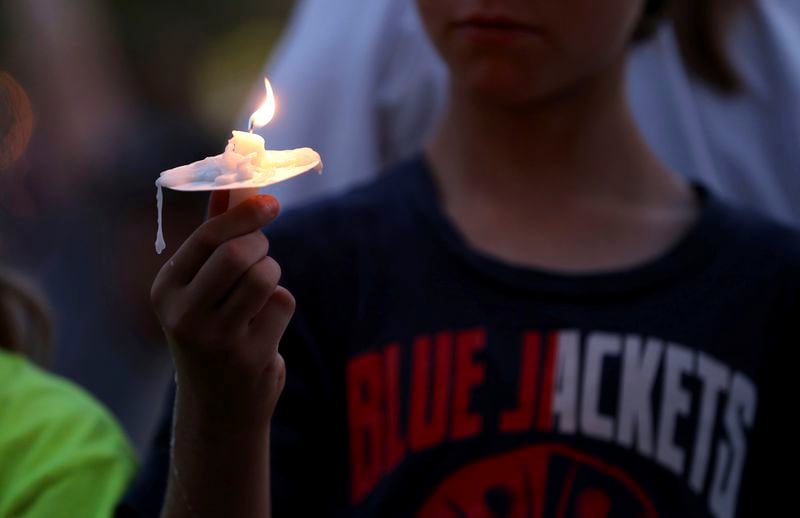 A Blue Jackets fan has a moment of silence during the candlelight vigil to honor Columbus Blue Jackets hockey player Johnny Gaudreau, outside of Nationwide Arena in Columbus, Ohio, Thursday, Sept. 4, 2024. Gaudreau and his brother Matthew were killed by a motor vehicle last week while riding bicycles. (AP Photo/Joe Maiorana)