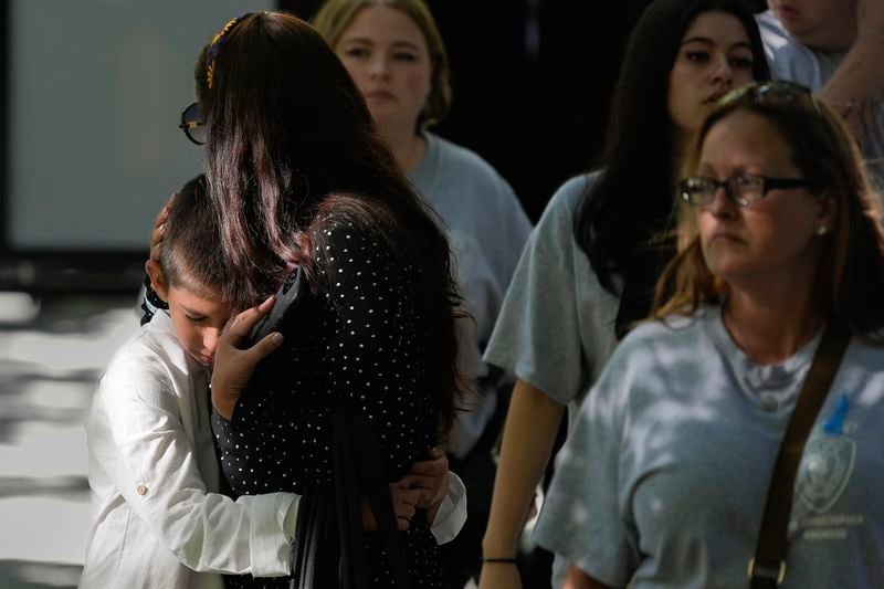 A boy hugs a woman while attending the 9/11 Memorial ceremony on the 23rd anniversary of the Sept. 11, 2001 terror attacks, Wednesday, Sept. 11, 2024, in New York. (AP Photo/Pamela Smith)