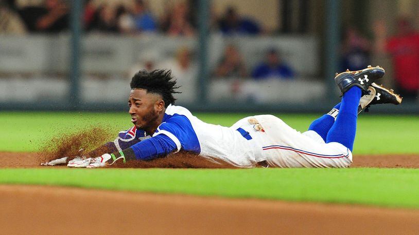 Atlanta Braves' Ozzie Albies slides into home to score as the ball