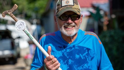 Jim Merritt, 73, of Buford, holds the white stick he took with him on his runs. He was nearing the important anniversary of 20 years of running every single day until COVID cut that streak short. He wasn't a runner when he began running 23 years ago. PHIL SKINNER FOR THE ATLANTA JOURNAL-CONSTITUTION.